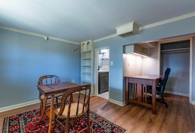 dining area featuring visible vents, crown molding, baseboards, and wood finished floors