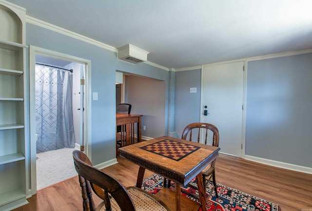 dining space featuring baseboards, ornamental molding, and wood finished floors