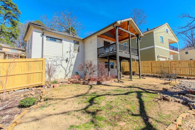 rear view of house featuring fence and ceiling fan