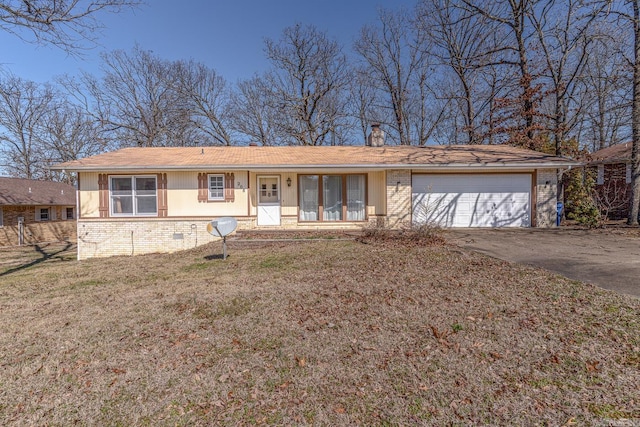 ranch-style home featuring brick siding, a front lawn, an attached garage, and aphalt driveway