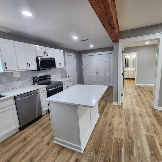 kitchen featuring visible vents, white cabinets, decorative backsplash, stainless steel appliances, and light wood-type flooring