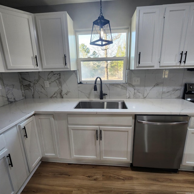 kitchen featuring dark wood finished floors, hanging light fixtures, white cabinets, a sink, and dishwasher