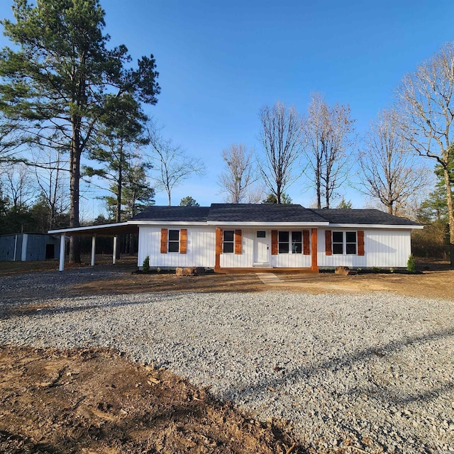 ranch-style house with driveway, a porch, and an attached carport