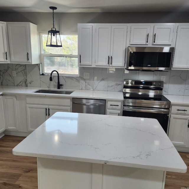 kitchen featuring dark wood-style floors, stainless steel appliances, backsplash, and a sink