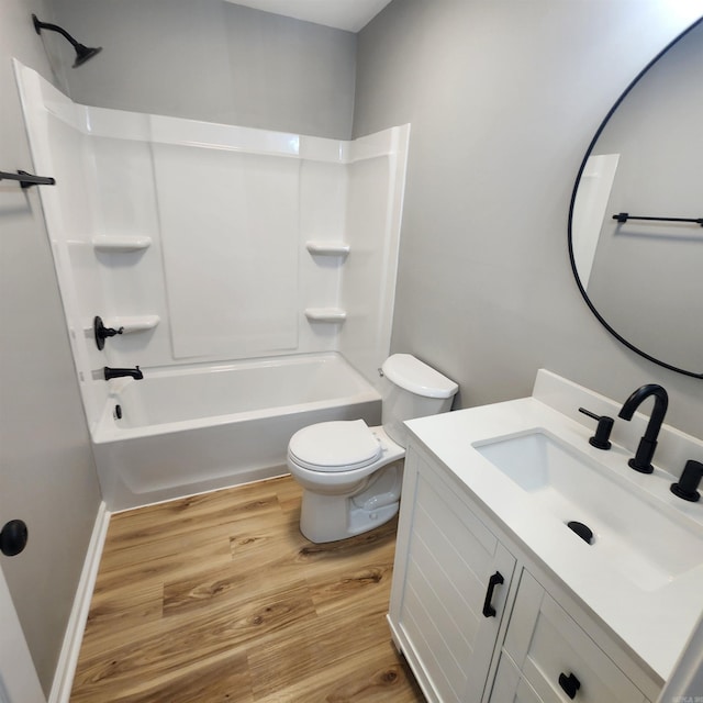 full bath with vanity, shower / washtub combination, wood finished floors, and toilet