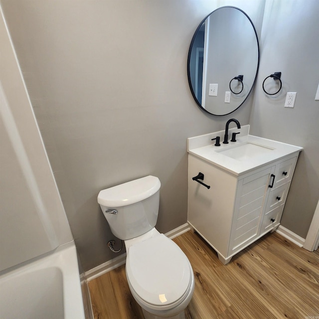 bathroom with vanity, wood finished floors, toilet, and baseboards