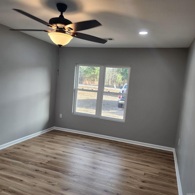 empty room with recessed lighting, visible vents, ceiling fan, wood finished floors, and baseboards