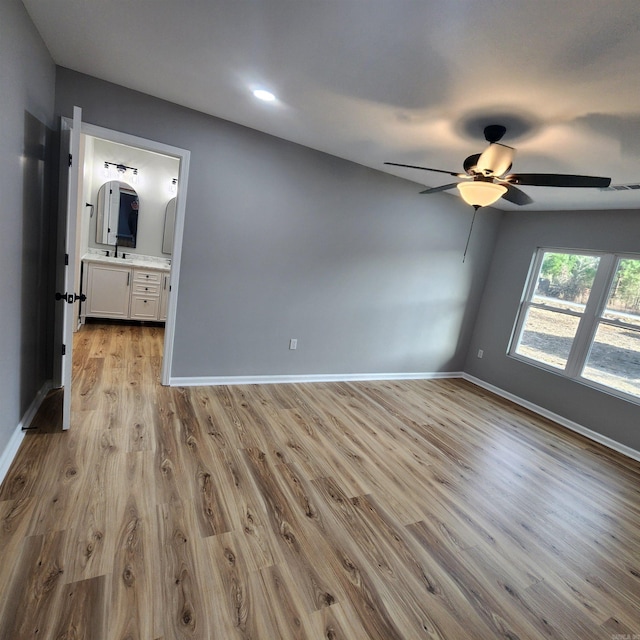 spare room with light wood-style floors, ceiling fan, visible vents, and baseboards