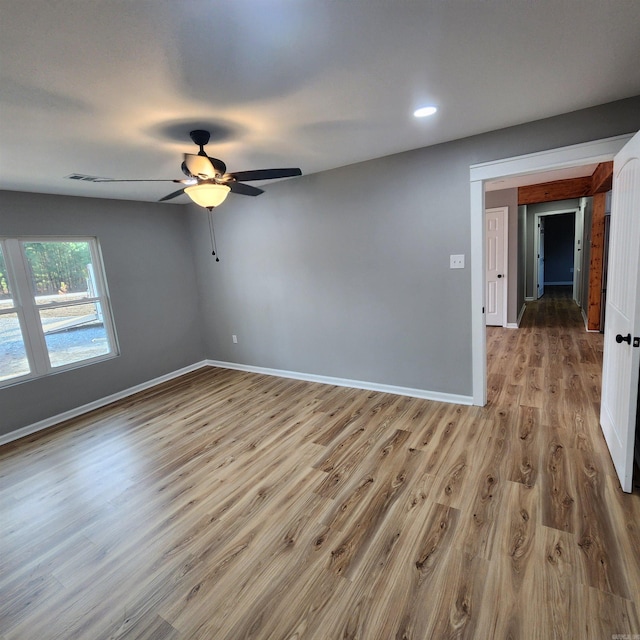 unfurnished room with recessed lighting, visible vents, a ceiling fan, wood finished floors, and baseboards