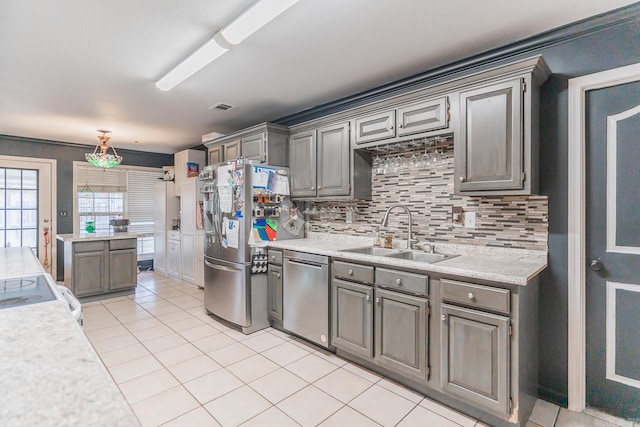 kitchen featuring visible vents, decorative backsplash, stainless steel appliances, light countertops, and a sink