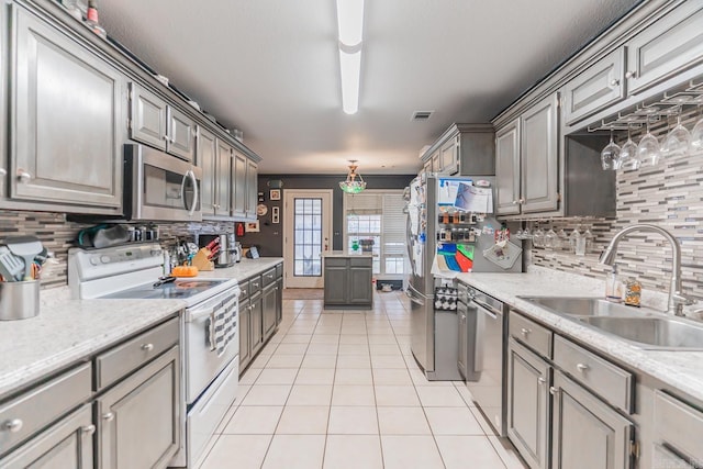 kitchen with light tile patterned flooring, a sink, visible vents, light countertops, and appliances with stainless steel finishes