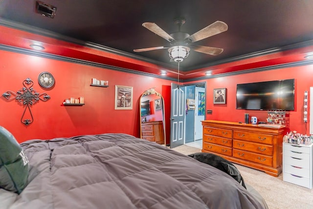 bedroom featuring visible vents, a raised ceiling, ceiling fan, crown molding, and carpet flooring