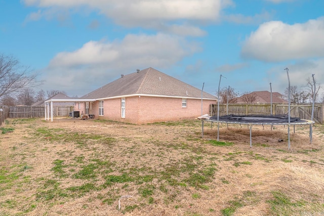 view of yard with a trampoline and a fenced backyard