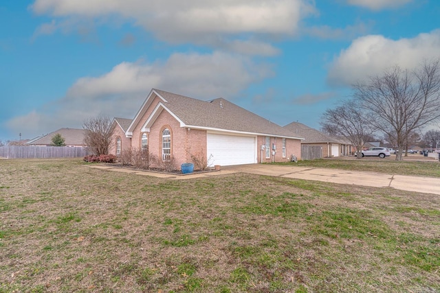 view of side of property featuring a garage, brick siding, fence, a yard, and driveway