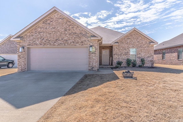 ranch-style home featuring a garage, a shingled roof, concrete driveway, and brick siding