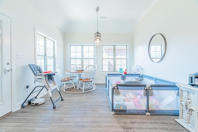 game room with vaulted ceiling, wood finished floors, visible vents, and baseboards