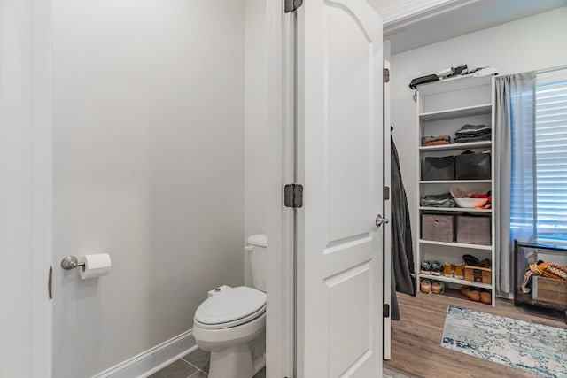 bathroom with toilet and baseboards