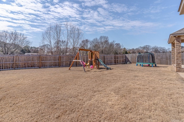 view of playground featuring a trampoline, a fenced backyard, and a lawn