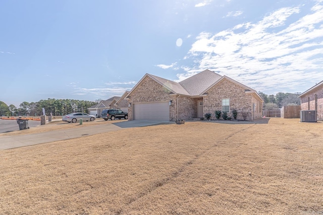 ranch-style home featuring cooling unit, a garage, brick siding, fence, and driveway