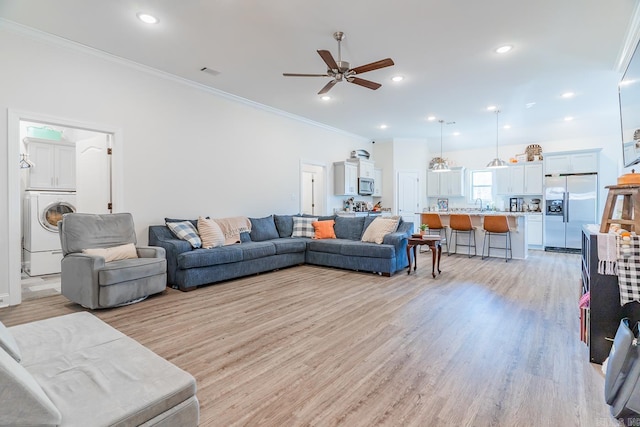 living room with light wood finished floors, visible vents, washer / clothes dryer, crown molding, and recessed lighting