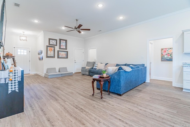 living area with light wood finished floors, baseboards, visible vents, a ceiling fan, and crown molding