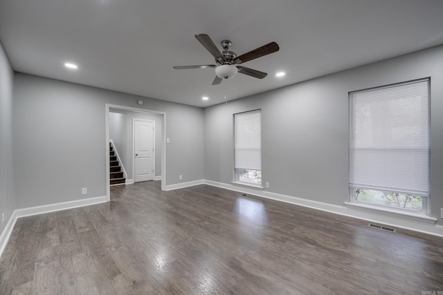 spare room with baseboards, visible vents, dark wood-type flooring, stairs, and recessed lighting