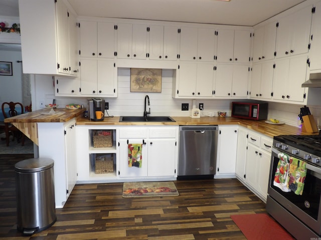 kitchen featuring appliances with stainless steel finishes, white cabinets, a sink, and under cabinet range hood