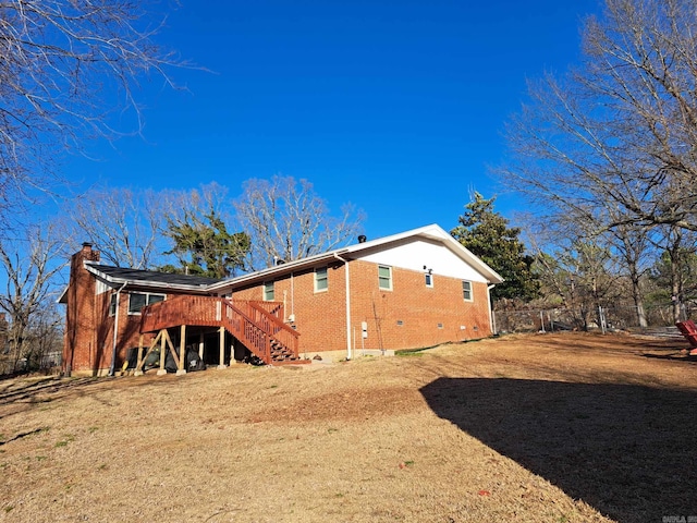 back of property with brick siding, a yard, stairway, crawl space, and a wooden deck