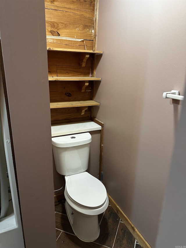 bathroom featuring baseboards and toilet