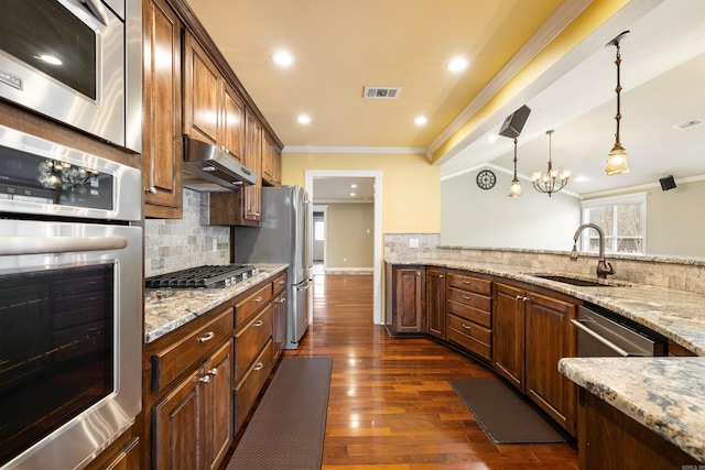 kitchen with visible vents, appliances with stainless steel finishes, ornamental molding, a sink, and under cabinet range hood