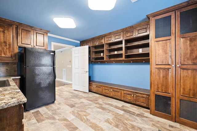 kitchen with light stone counters, ornamental molding, freestanding refrigerator, decorative backsplash, and open shelves