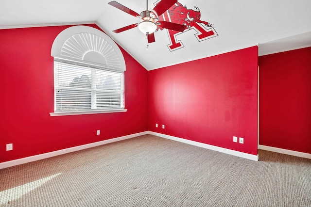 empty room with vaulted ceiling, ceiling fan, carpet, and baseboards