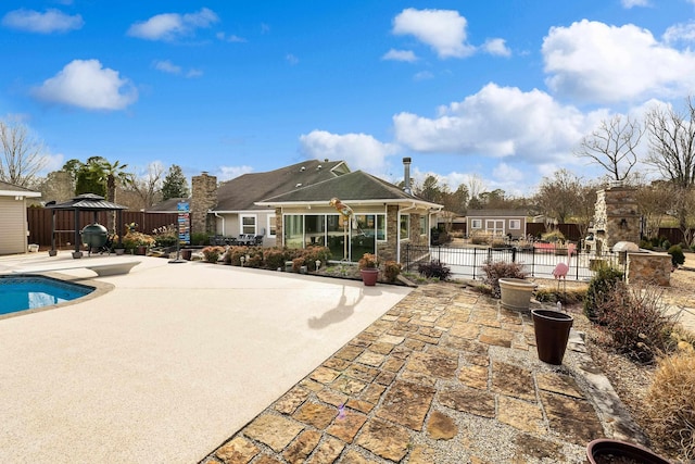 back of property featuring a patio, a gazebo, fence, and a fenced in pool