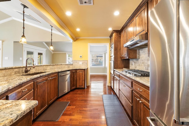 kitchen with stainless steel appliances, crown molding, a sink, and under cabinet range hood