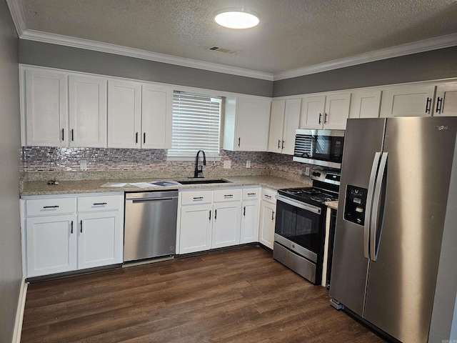 kitchen featuring dark wood finished floors, stainless steel appliances, visible vents, white cabinets, and a sink