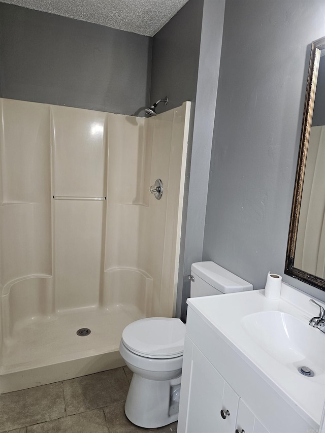 full bath with vanity, a textured ceiling, toilet, and a walk in shower