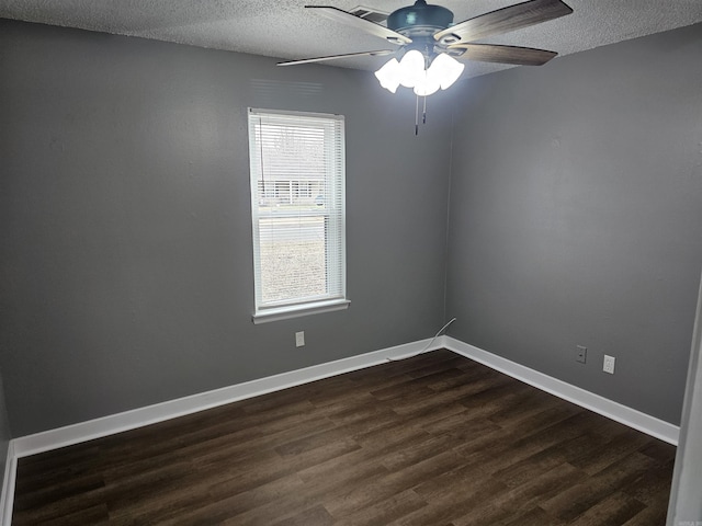 empty room with dark wood-style flooring, ceiling fan, a textured ceiling, and baseboards