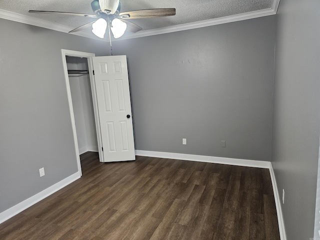 unfurnished bedroom featuring a textured ceiling, dark wood finished floors, and crown molding