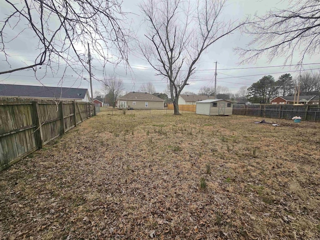 view of yard featuring a fenced backyard, an outdoor structure, and a storage shed