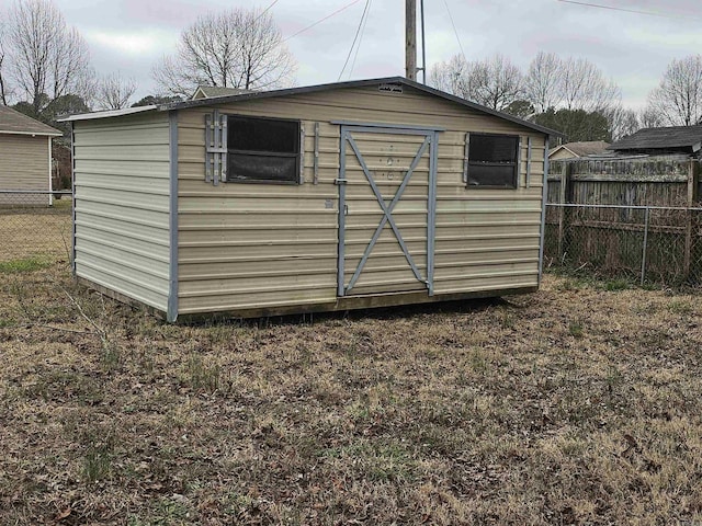 view of outbuilding with fence and an outbuilding