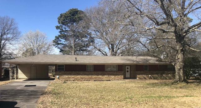 single story home with an attached carport, brick siding, driveway, and a front lawn