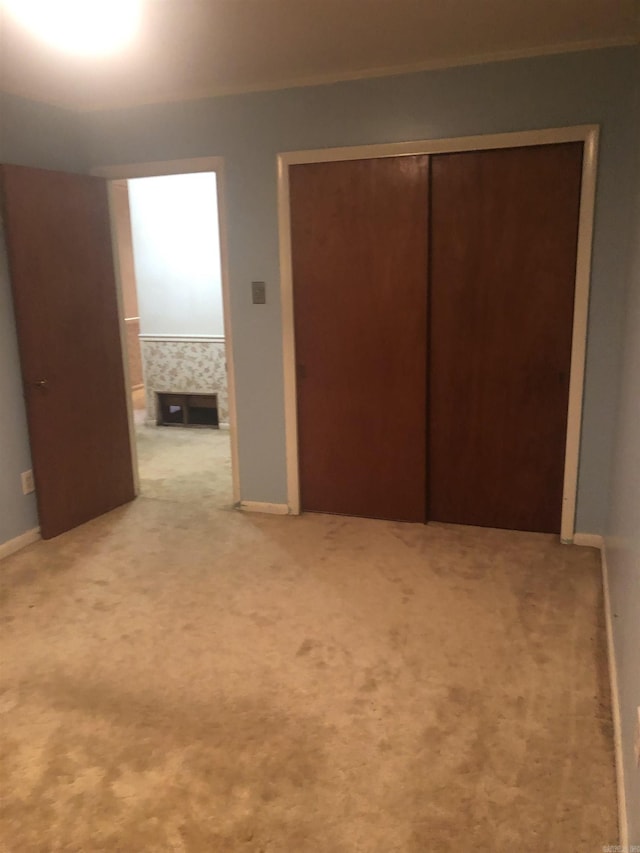 unfurnished bedroom with carpet floors, baseboards, and a closet