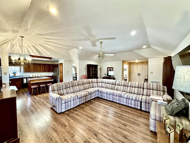 312 State St, Dardanelle, AR 72834 - living area with dark wood finished floors, lofted ceiling, recessed lighting, visible vents, and ceiling fan with notable chandelier