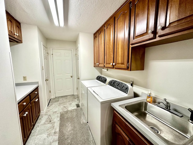 312 State St, Dardanelle, AR 72834 - clothes washing area featuring cabinet space, baseboards, a textured ceiling, separate washer and dryer, and a sink