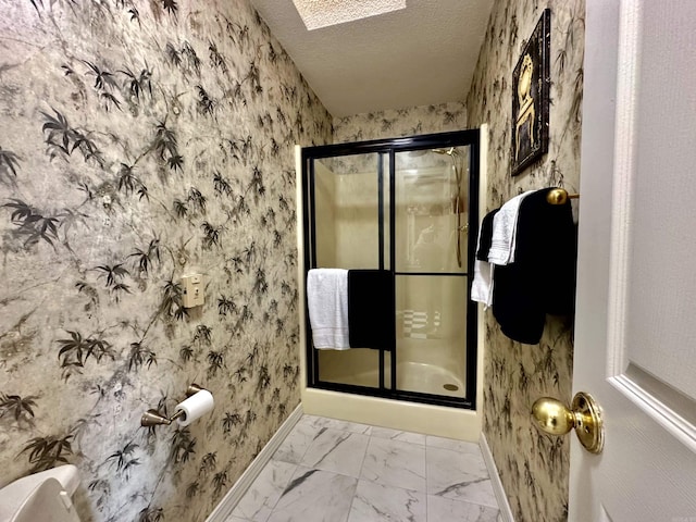 312 State St, Dardanelle, AR 72834 - bathroom featuring a textured ceiling, baseboards, marble finish floor, a shower stall, and wallpapered walls