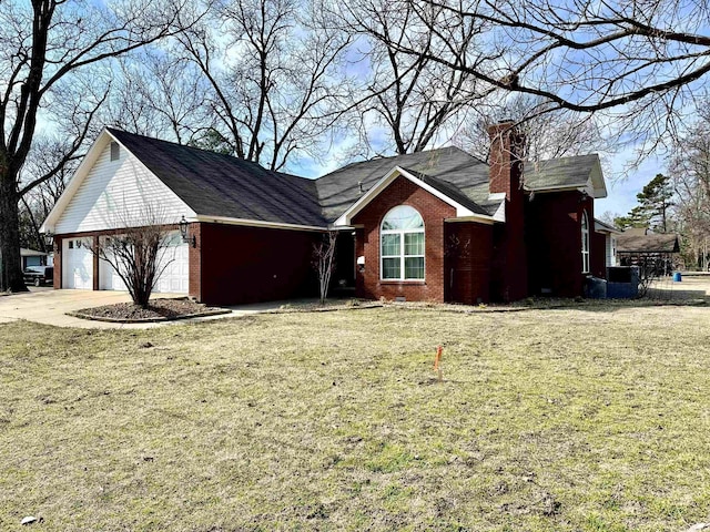 312 State St, Dardanelle, AR 72834 - view of side of home featuring a garage, concrete driveway, a chimney, a yard, and brick siding