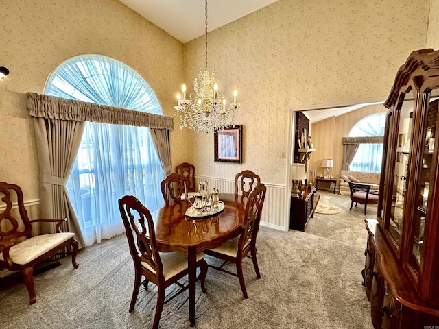 312 State St, Dardanelle, AR 72834 - carpeted dining area with lofted ceiling, wallpapered walls, a notable chandelier, and a wealth of natural light