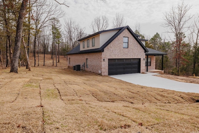 view of side of property featuring driveway, brick siding, an attached garage, and central air condition unit