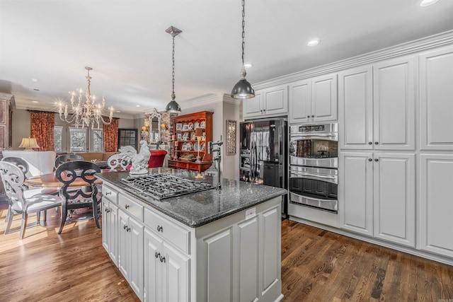 kitchen with open floor plan, stainless steel appliances, white cabinets, and a center island