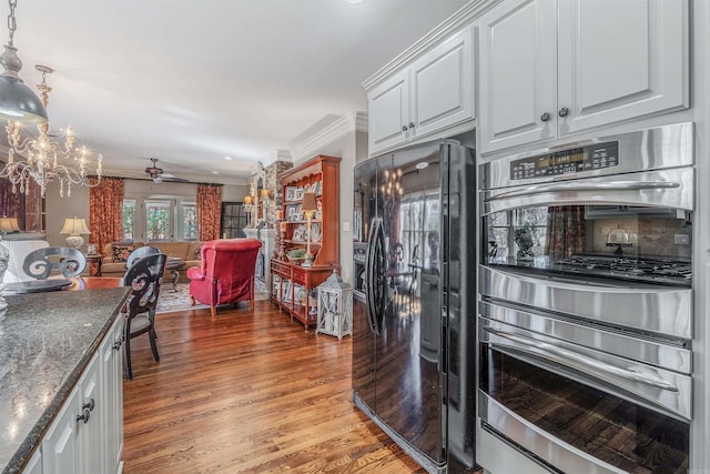 kitchen with crown molding, black refrigerator with ice dispenser, light wood-style flooring, stainless steel double oven, and white cabinets